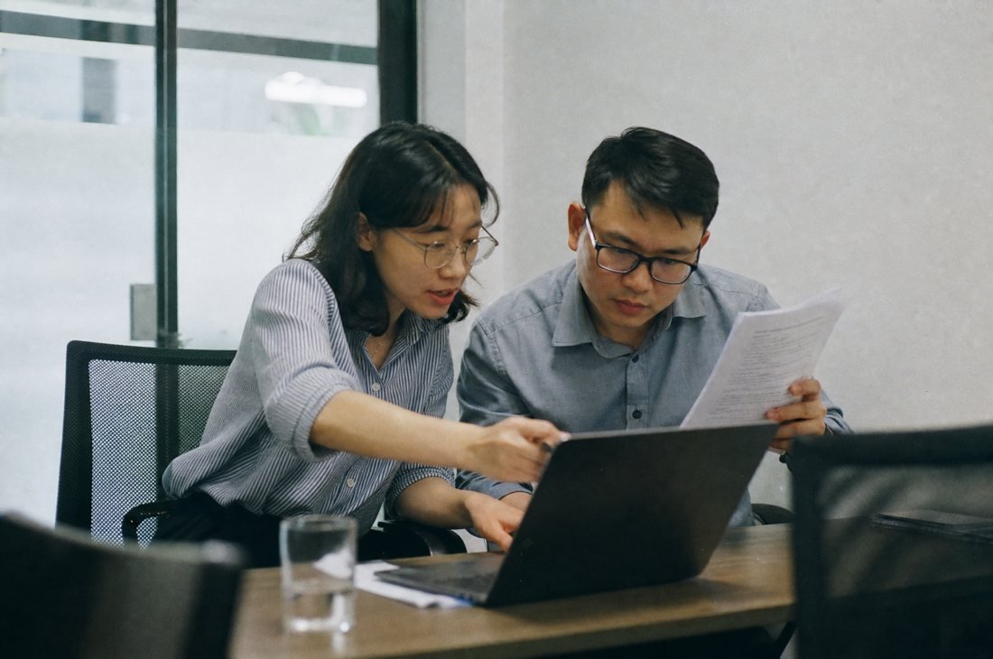 Trình hồ sơ: hai đồng nghiệp cùng xem shortlist trên laptop
